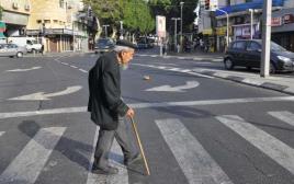 קשיש חוצה את הכביש בתל אביב (צילום: סרג' אטאל, פלאש 90)
