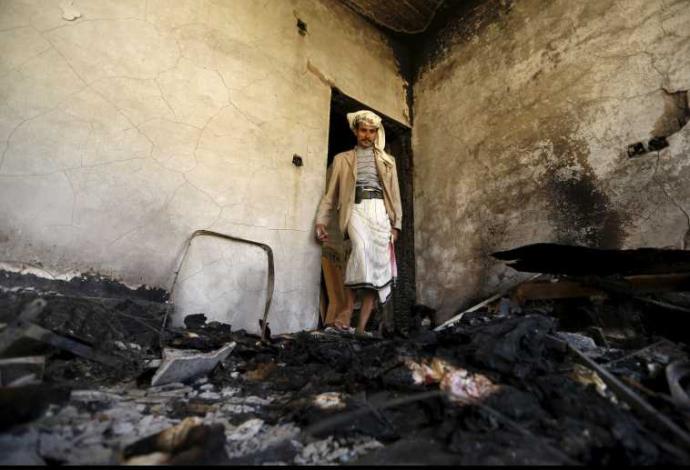 אדם עומד בבית שהופצץ בתימן (צילום:  רויטרס)