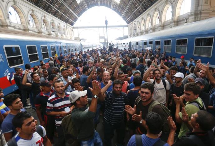 מהגרים ממתינים בתחנת הרכבת של בודפשט (צילום:  רויטרס)