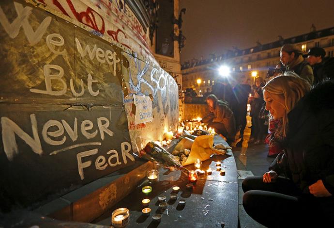 מניחים פרחים ונרות ליד אזור הירי, מתקפת טרור בפריז (צילום:  רויטרס)