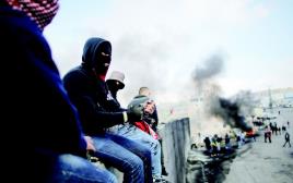 פלסטינים על גדר ההפרדה בירושלים (צילום: רויטרס)