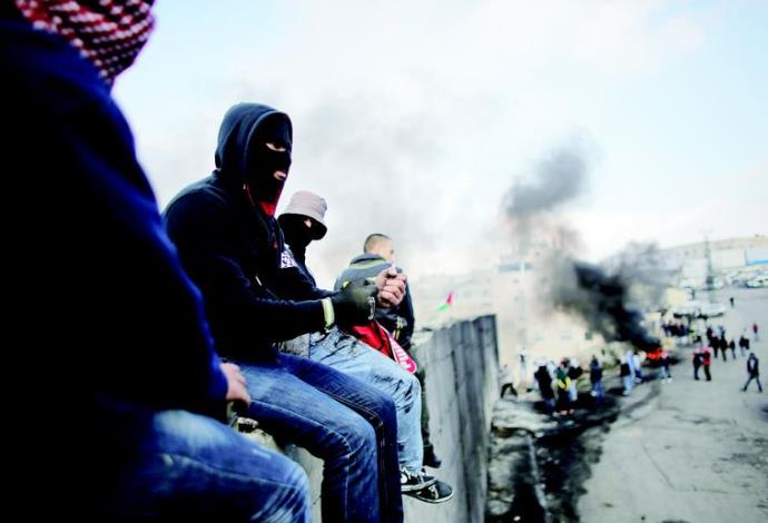 פלסטינים על גדר ההפרדה בירושלים (צילום:  רויטרס)