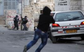 יידוי אבנים על שוטרי מג"ב בידי צעיר פלסטיני (צילום: פלאש 90)