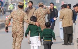 חיילים פקיסטנים מחוץ לבית הספר בו אירע הפיגוע  (צילום: רויטרס)