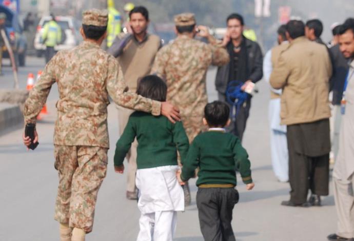 חיילים פקיסטנים מחוץ לבית הספר בו אירע הפיגוע  (צילום:  רויטרס)
