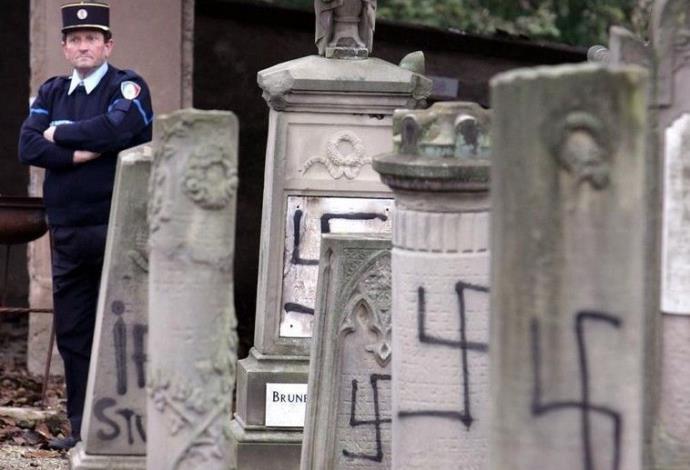 שוטר צרפתי בבית קברות יהודי שחולל ליד שטרסבורג (צילום:  רויטרס)