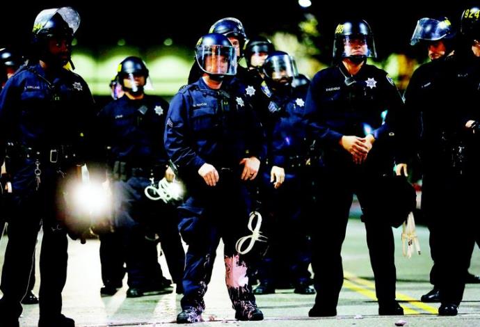 היד קלה על ההדק. שוטרים פרוסים בשטח במהלך הפגנה נגד אלימות משטרתית באוקלנד, קליפורניה  (צילום:  רויטרס)