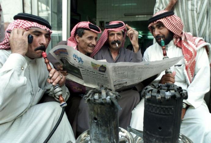 עיראקים קוראים עיתון בערבית (צילום:  רויטרס)