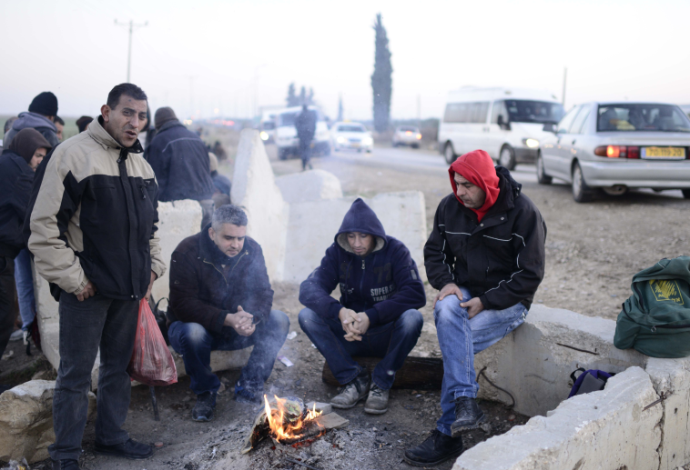 פועלים פלסטינים מחכים להסעות במחסום אייל (צילום:  תומר ניוברג, פלאש 90)