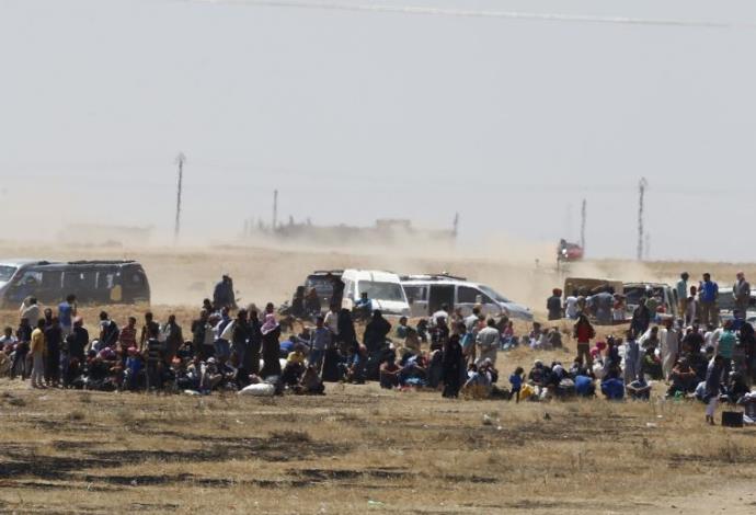 פליטים נמלטים מארגון דאעש בסוריה (צילום:  רויטרס)