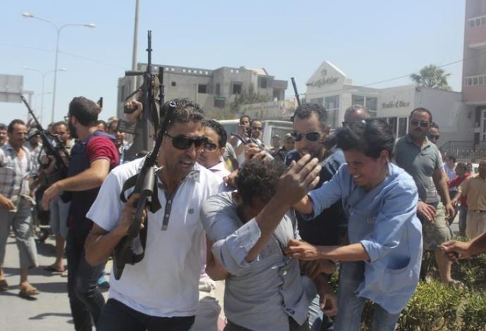 המשטרה המקומית מנסה להרגיע את הקהל בזמן המצוד אחר המחבל בפיגוע בתוניסיה (צילום:  רויטרס)