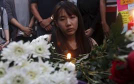 אשה מדליקה נר לזכר ההרוגים בפיגוע במקדש (צילום: רויטרס)