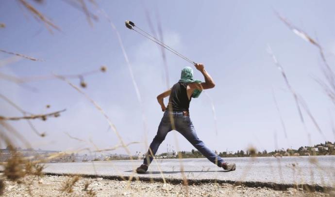 צעיר פלסטיני מיידה אבנים, החודש באזור רמאללה (צילום: רויטרס)