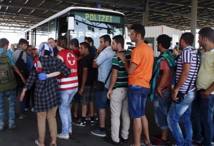מהגרים שנעצרו באוסטריה מחכים להסעה למתקני קליטה (צילום:  רויטרס)