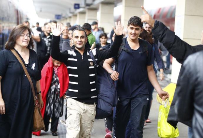 פליטים מחייכים אחרי שהגיעו לאוסטריה (צילום:  רויטרס)