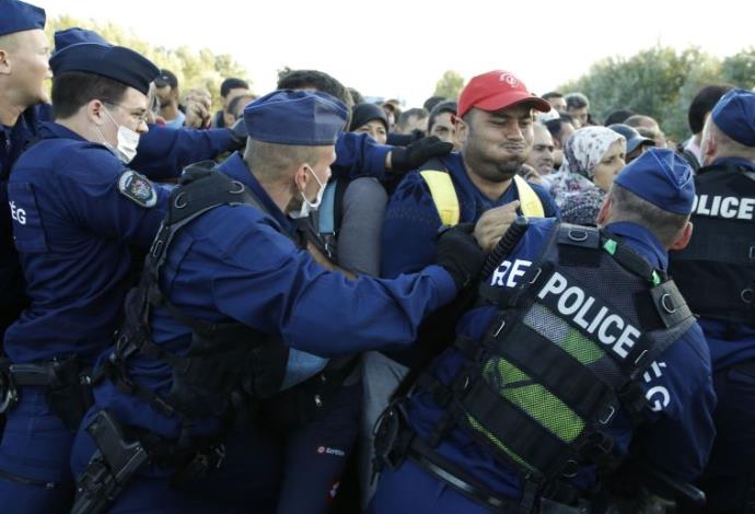 שוטרים הונגרים נאבקים עם מהגרים בגבול סרביה  (צילום:  רויטרס)
