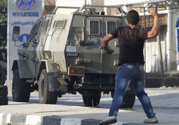 צעירים פלסטינים משליכים אבנים במהלך עימותים עם צה"ל. צילום: רויטרס