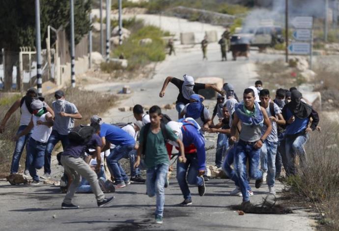 צעירים פלסטינים בעימותים עם כוחות צה"ל סמוך לבית אל (צילום:  רויטרס)
