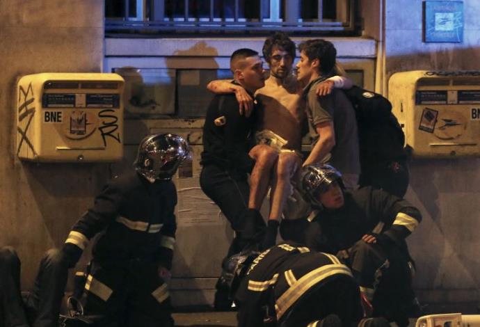 כבאים מחלצים פצועים מאולם בטקלן בפריז  (צילום:  רויטרס)