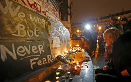 מניחים פרחים ונרות ליד אזור הירי, מתקפת טרור בפריז (צילום: רויטרס)