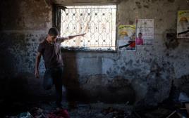 נער פלסטיני מביט על הנזק בבית שהוצת בדומא  (צילום: מרים אלסטר, פלאש 90)