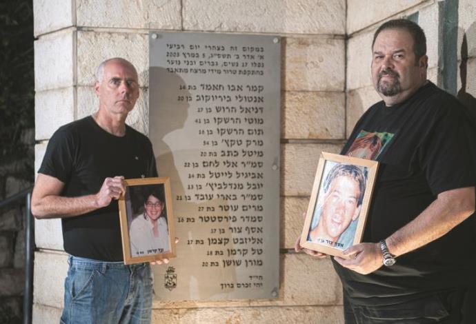 רון קרמן (משמאל) ויוסי צור עם תמונות ילדיהם באנדרטה לזכר נרצחי הפיגוע בקו 37 (צילום:  דורון גולן, סוכנות ג'יני)