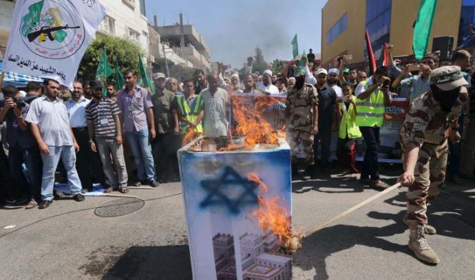 פעילי מאס שורפים דגל ישראל בחאן יונס (צילום: רויטרס)