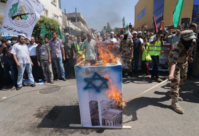 פעילי מאס שורפים דגל ישראל בחאן יונס (צילום:  רויטרס)