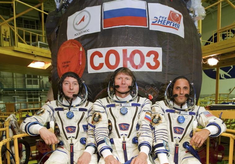 עקבה (מימין) ליד החללית הרוסית "סיוז". צילום: רויטרס