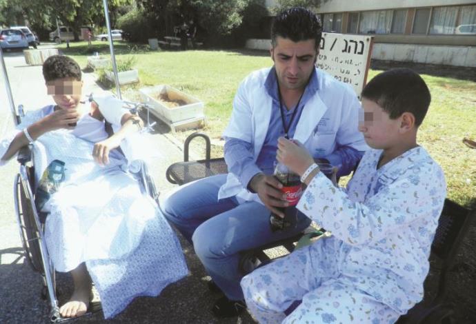  פארס עיסא עם ילדים סורים פצועים במרכז הרפואי זיו (צילום:  יח"צ)