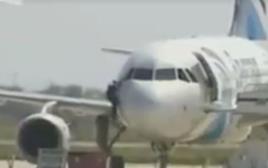 חוטף המטוס המצרי יוצא דרך חלון תא הטייס (צילום: צילום מסך פייסבוק)