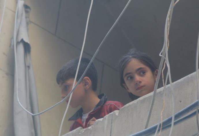 ילדים מביטים על ההריסות בעיר חלב (צילום:  רויטרס)