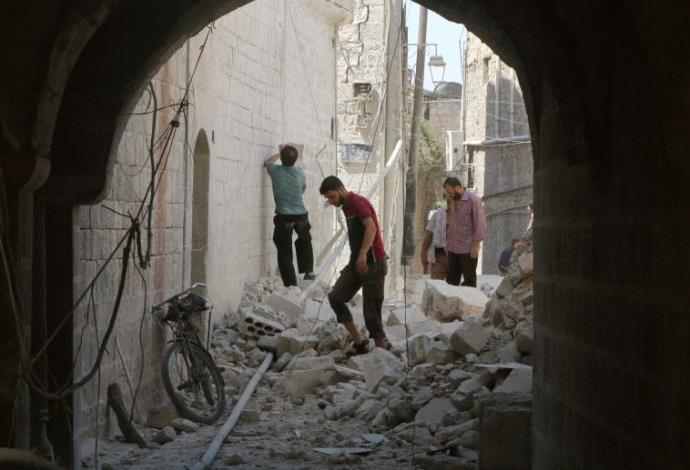 תושבי חאלב בודקים את הנזק לאחר ההפצצות בעיר (צילום:  רויטרס)