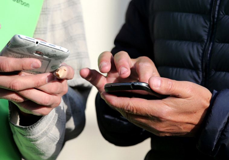 אנשים מחזיקים טלפונים סלולריים (צילום: Getty images)