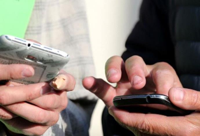 אנשים מחזיקים טלפונים סלולריים (צילום:  Getty images)